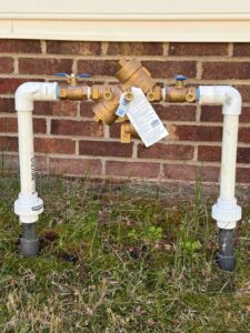 New brass backflow preventer installed on an irrigation line in Cary, NC by Cary Sprinklers & French Drains