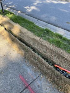 Drainage trench installed along a sidewalk to move standing water in Cary, NC