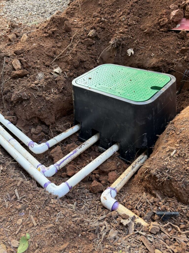 Clean irrigation valve box installation with new PVC piping in a Cary, NC yard
